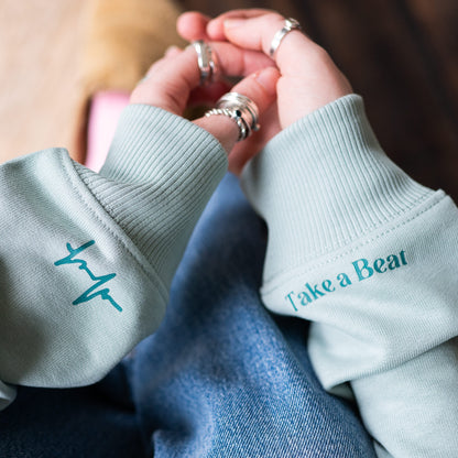 Close-up of Take A Beat sleeve in Aloe colour by Every Little Thread